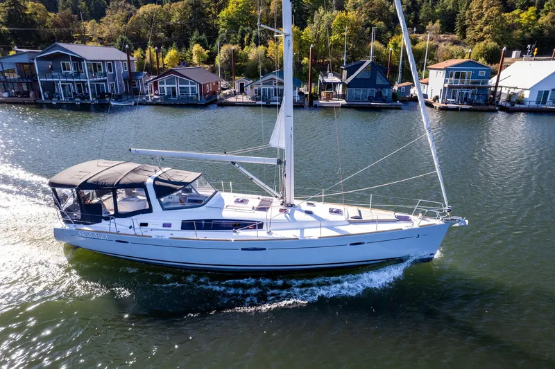 Slide: The Image of 2013 Beneteau Oceanis 50 sailing near waterfront homes on a sunny day. - 2