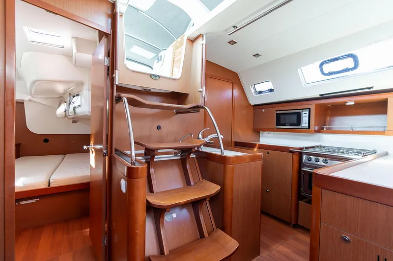 Slide: The Image of 2013 Beneteau Oceanis 50 yacht interior with kitchen, stairs, and cabin view. - 22