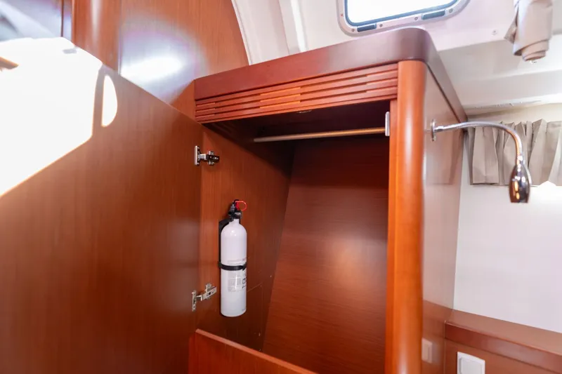 Slide: The Image of 2013 Beneteau Oceanis 50 interior closet with fire extinguisher and wooden finish. - 25