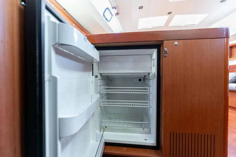 Slide: The Image of Open refrigerator inside 2013 Beneteau Oceanis 50 yacht, showcasing interior shelving. - 34