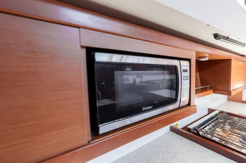 Slide: The Image of Microwave in 2013 Beneteau Oceanis 50 yacht kitchen with wooden cabinetry. - 36