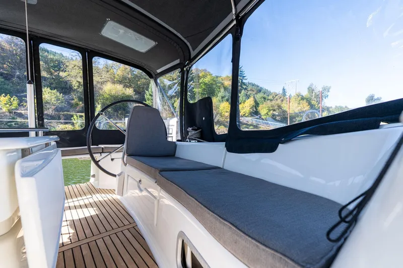 Slide: The Image of Cockpit of 2013 Beneteau Oceanis 50 sailboat with cushioned seating and steering wheel. - 52
