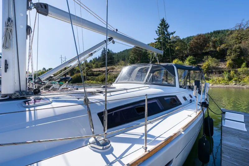 Slide: The Image of 2013 Beneteau Oceanis 50 sailboat docked, surrounded by lush greenery and calm waters. - 58