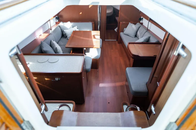 Slide: The Image of Interior of 2013 Beneteau Oceanis 50 yacht, featuring elegant wood finish and cozy seating. - 6