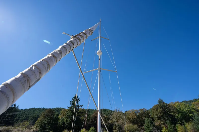 Slide: The Image of Mast of 2013 Beneteau Oceanis 50 sailboat against clear blue sky and forest backdrop. - 65