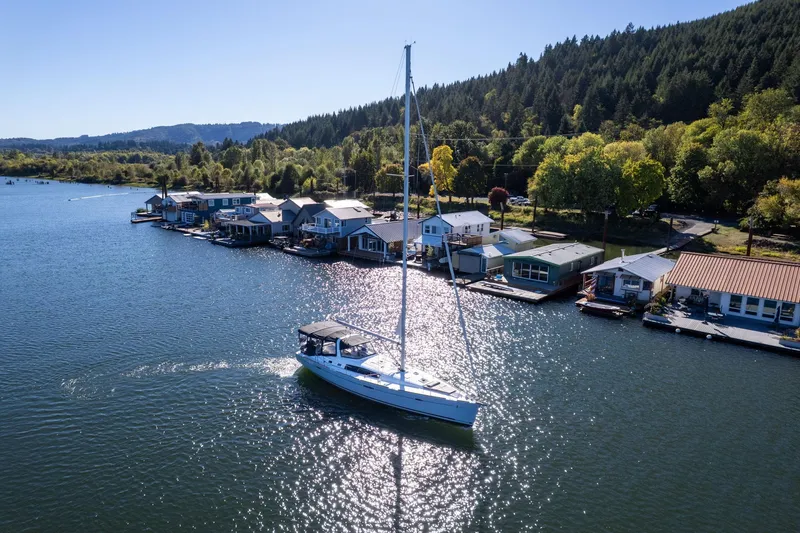 Slide: The Image of Sailboat Beneteau Oceanis 50 (2013) cruising near waterfront homes on a sunny day. - 71