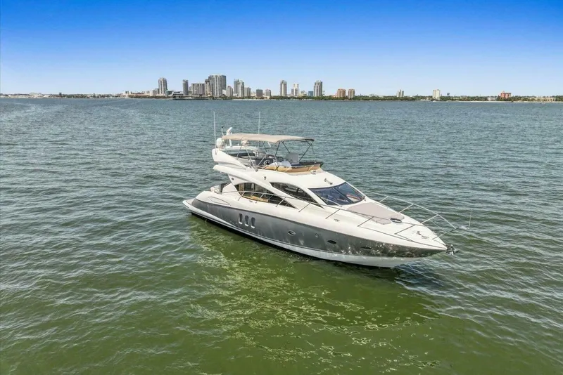 Slide: The Image of 2009 Sunseeker Manhattan 52 yacht on open water with city skyline backdrop. - 1