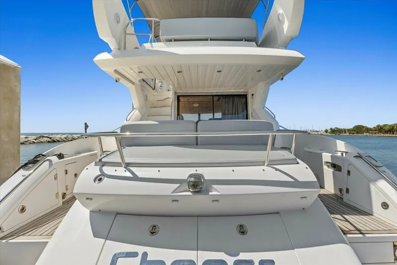 Slide: The Image of 2009 Sunseeker Manhattan 52 yacht, rear view, docked by the sea under clear blue sky. - 11