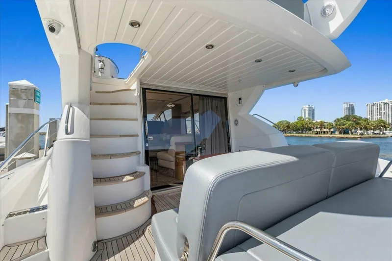 Slide: The Image of 2009 Sunseeker Manhattan 52 yacht interior with stairs and seating, docked by waterfront. - 14