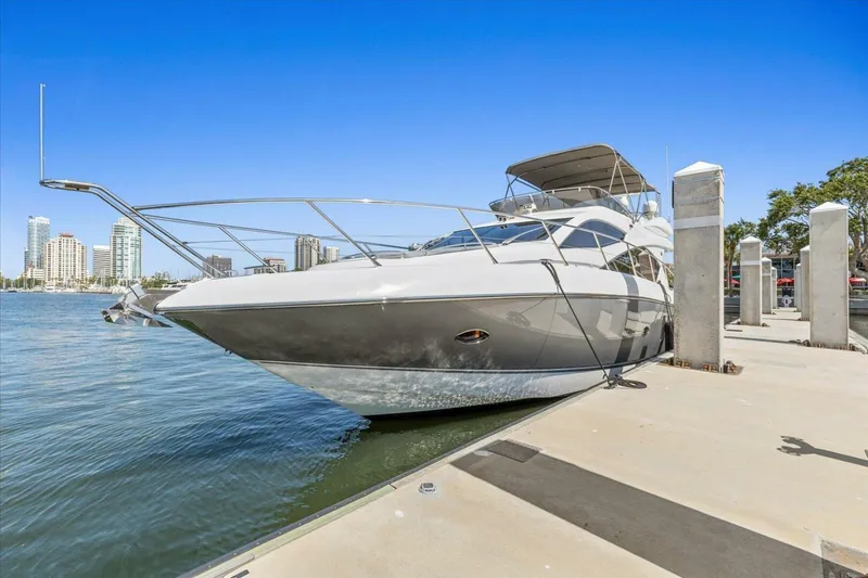 Slide: The Image of 2009 Sunseeker Manhattan 52 yacht docked at marina with city skyline backdrop. - 2