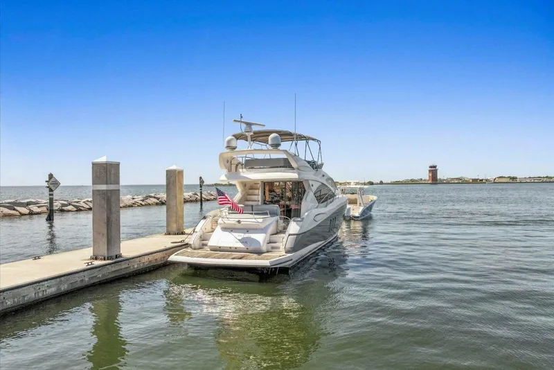 Slide: The Image of 2009 Sunseeker Manhattan 52 yacht docked at marina with clear blue sky. - 4