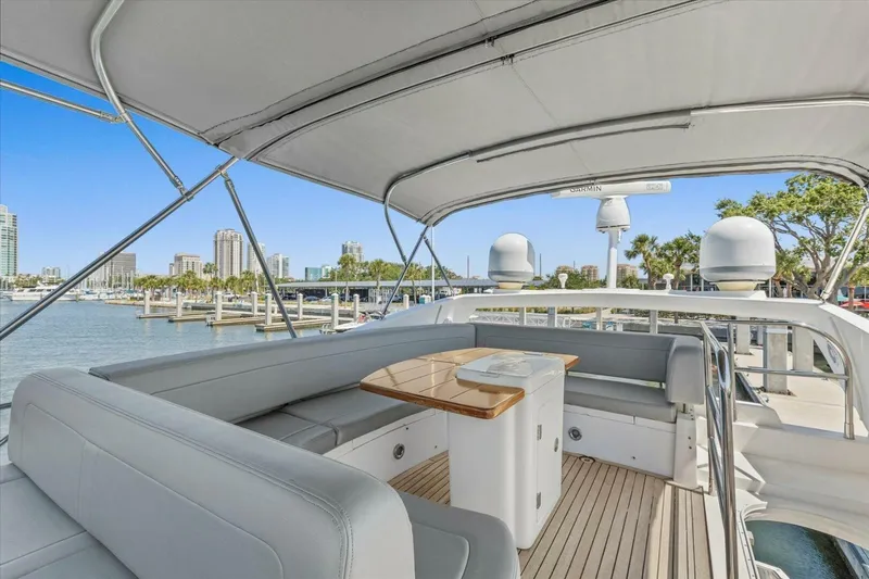 Slide: The Image of 2009 Sunseeker Manhattan 52 yacht deck with seating and table, docked by palm trees. - 47
