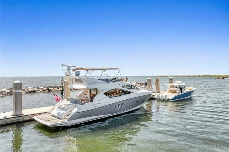 Slide: The Image of 2009 Sunseeker Manhattan 52 yacht docked at a marina under clear blue skies. - 5