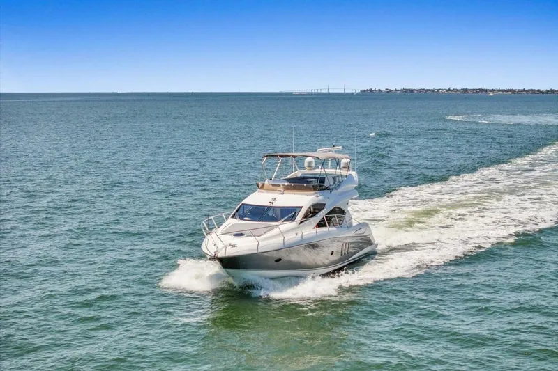 Slide: The Image of 2009 Sunseeker Manhattan 52 yacht cruising on open water under clear blue sky. - 59