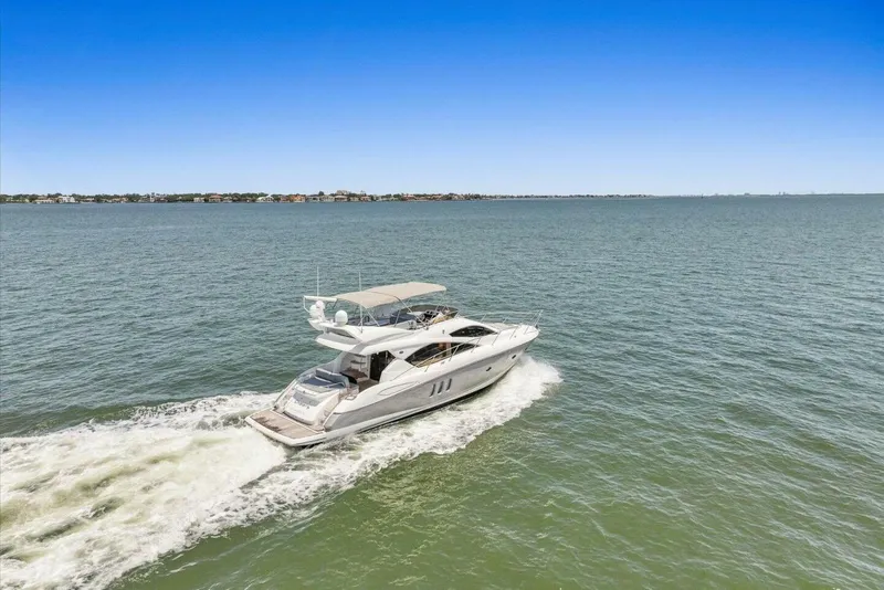 Slide: The Image of 2009 Sunseeker Manhattan 52 yacht cruising on open water under clear blue sky. - 6