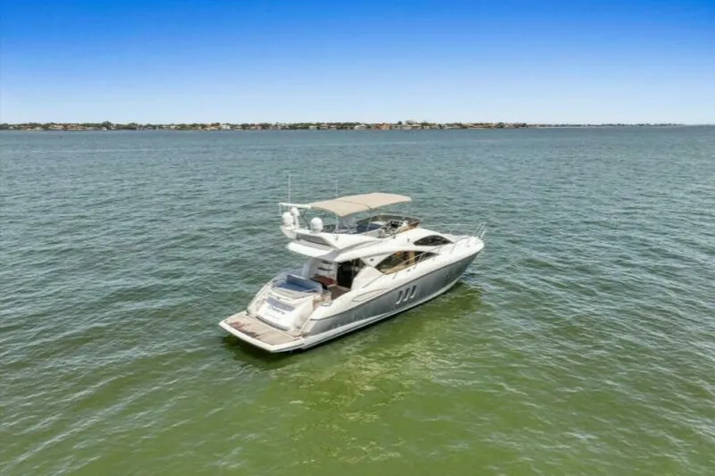 Slide: The Image of 2009 Sunseeker Manhattan 52 yacht on open water, distant city skyline. - 64