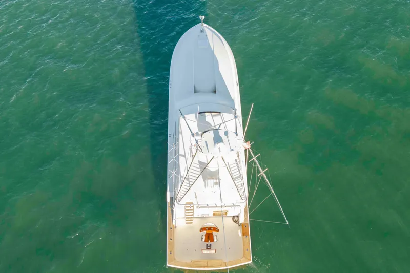Slide: The Image of Aerial view of 1999 Bertram 60 Convertible yacht on clear green water. - 10