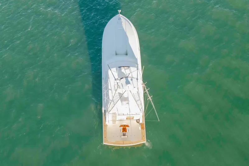 Slide: The Image of Aerial view of 1999 Bertram 60 Convertible yacht cruising in clear green waters. - 13
