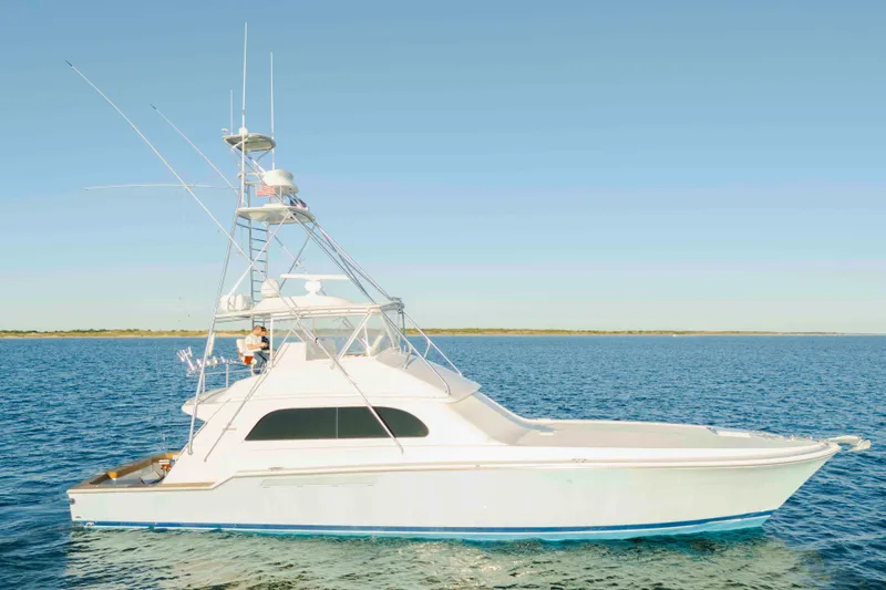 Slide: The Image of 1999 Bertram 60 Convertible yacht cruising on open water under clear skies. - 16