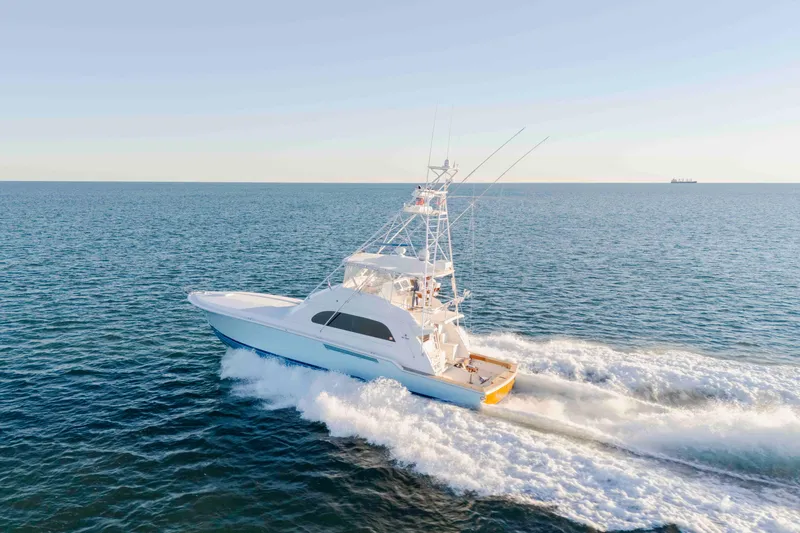 Slide: The Image of 1999 Bertram 60 Convertible yacht cruising on open sea under clear sky. - 19