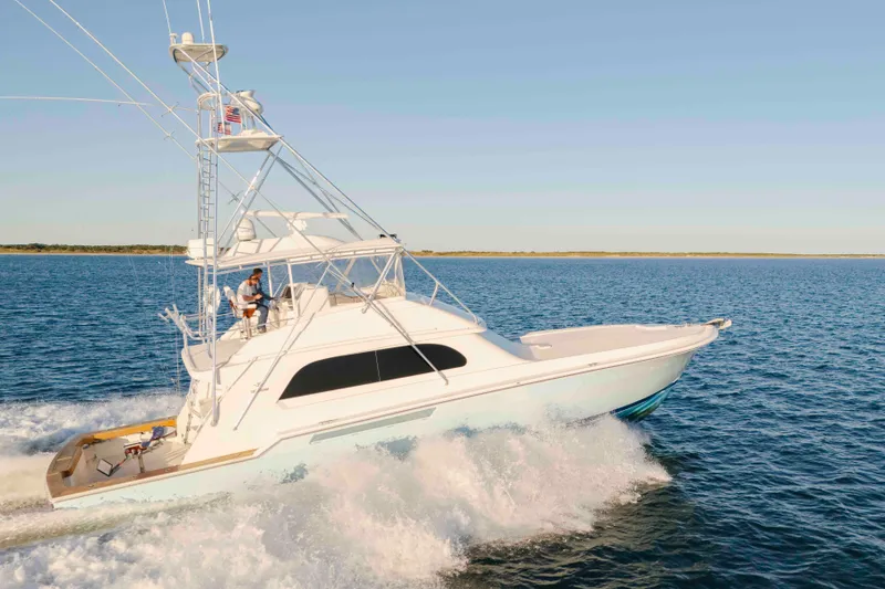 Slide: The Image of 1999 Bertram 60 Convertible yacht cruising on open water under clear skies. - 20