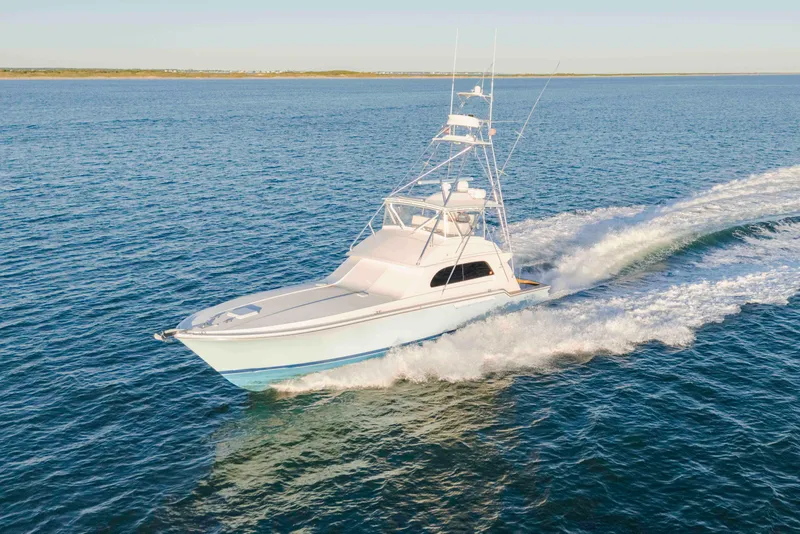 Slide: The Image of 1999 Bertram 60 Convertible yacht cruising on open water. - 24