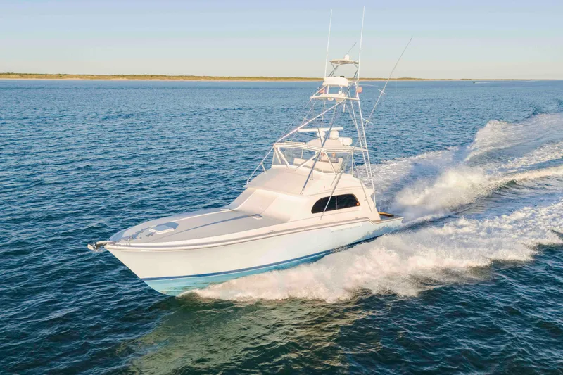 Slide: The Image of 1999 Bertram 60 Convertible yacht cruising on open water. - 29