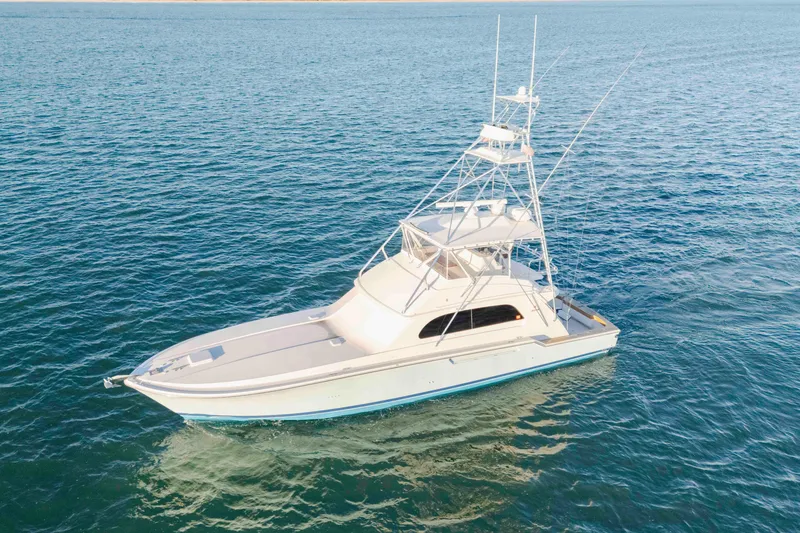 Slide: The Image of 1999 Bertram 60 Convertible yacht cruising on open blue waters. - 30