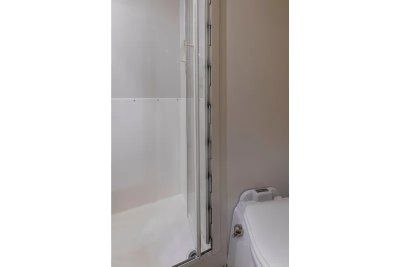 Slide: The Image of Bathroom interior of 1999 Bertram 60 Convertible yacht, featuring shower and toilet. - 35