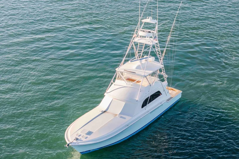 Slide: The Image of 1999 Bertram 60 Convertible yacht on calm blue water, aerial view. - 6