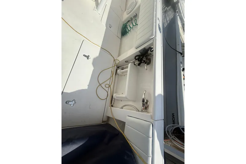 Slide: The Image of 2013 Intrepid 327 Cuddy boat deck with storage compartments and coiled hose. - 10