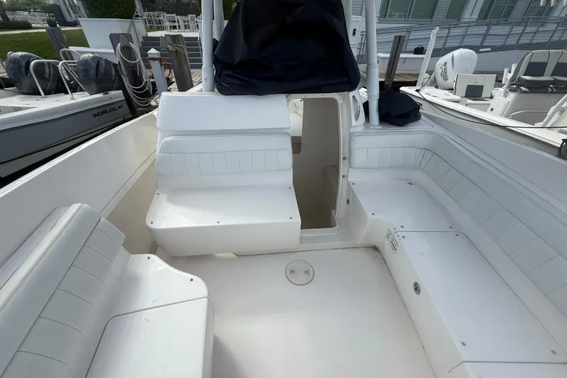 Slide: The Image of 2013 Intrepid 327 Cuddy boat interior with white seating and open cabin entrance. - 15