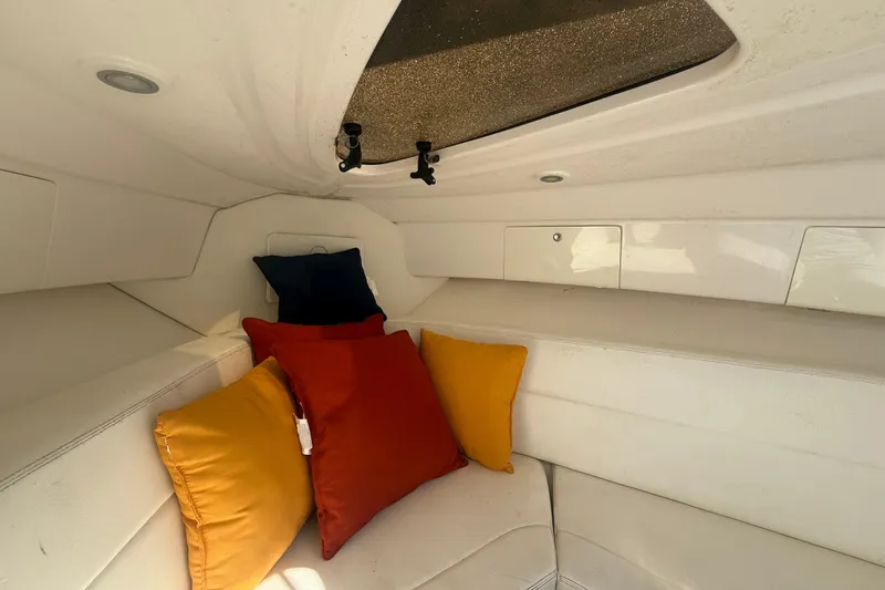 Slide: The Image of 2013 Intrepid 327 Cuddy cabin interior with colorful cushions and white seating. - 16