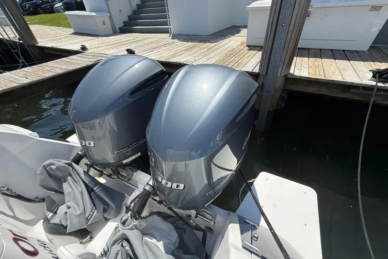 Slide: The Image of Twin outboard engines on a 2013 Intrepid 327 Cuddy boat docked by wooden pier. - 28