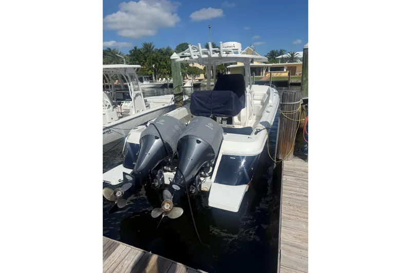 Slide: The Image of 2013 Intrepid 327 Cuddy boat docked with dual outboard engines. - 3