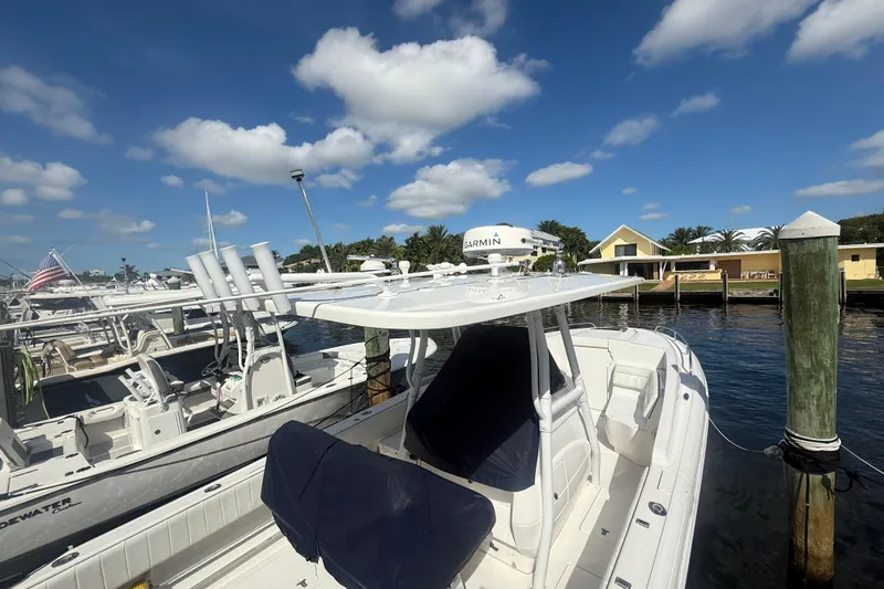 Slide: The Image of 2013 Intrepid 327 Cuddy boat docked at marina under blue sky. - 5