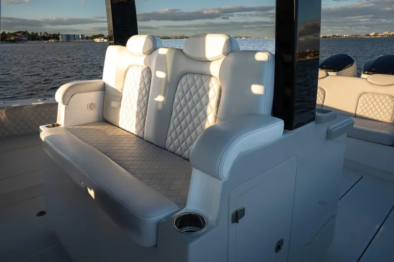 Slide: The Image of 2024 HCB 42 Lujo boat cruising on calm waters near a marina. - 13