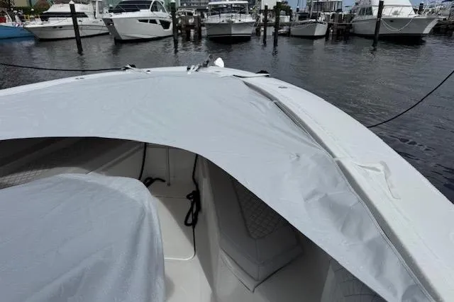 Slide: The Image of 2024 HCB 42 Lujo boat with luxurious seating, docked by a scenic lakeside. - 54