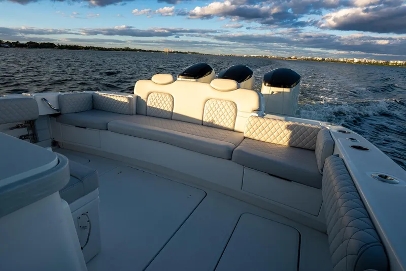 Slide: The Image of 2024 HCB 42 Lujo boat with triple outboard engines on open water. - 8