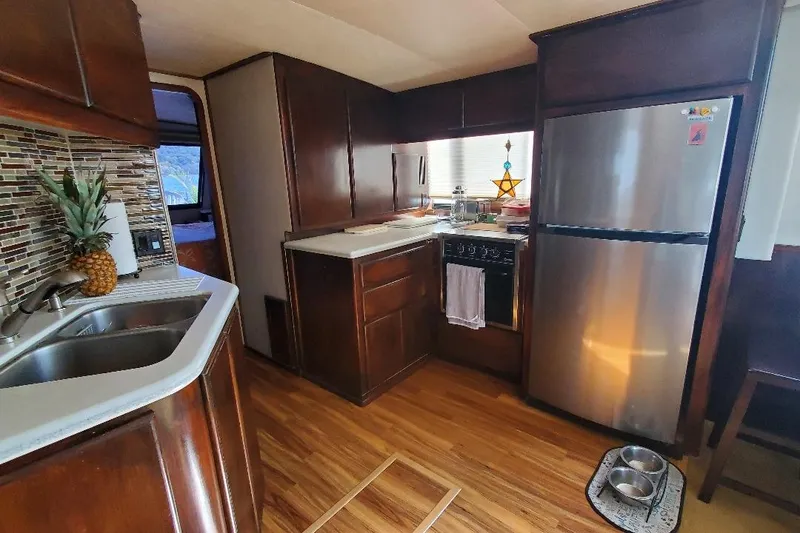 Slide: The Image of Interior of 1992 Bluewater 54 Coastal Cruiser kitchen with modern appliances and wood finish. - 4
