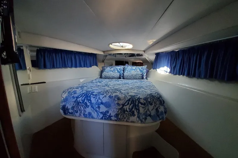 Slide: The Image of Interior cabin of 1992 Bluewater 54 Coastal Cruiser with blue floral bedding. - 7