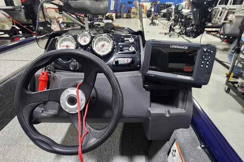 Slide: The Image of 2021 Tracker Pro 170 boat dashboard with steering wheel and Lowrance fish finder. - 5
