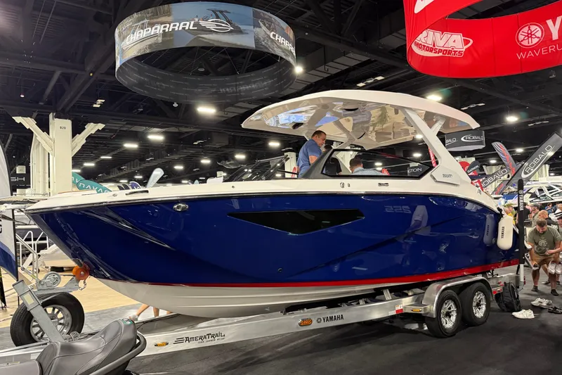 The Image of 2026 Yamaha Boats 295SD displayed at a boat show, featuring sleek blue design. - 0