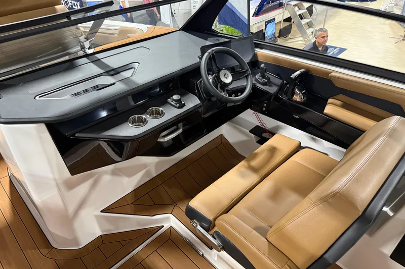 Slide: The Image of 2026 Yamaha Boats 295SD interior with modern helm, tan seating, and sleek dashboard design. - 11