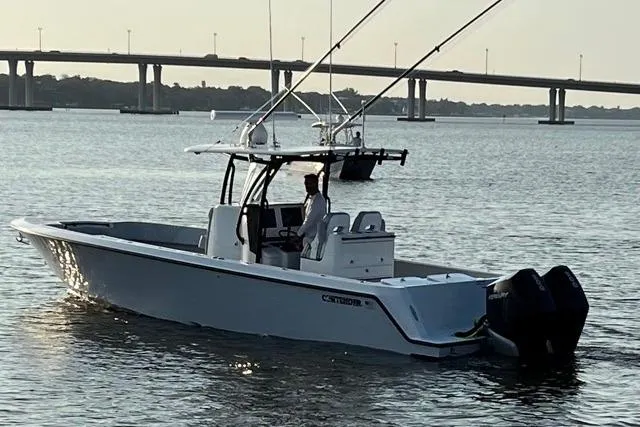 Slide: The Image of 2023 Contender 32 ST boat on trailer with Mercury outboard, parked near palm trees. - 1
