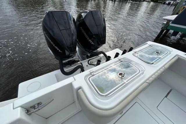 Slide: The Image of 2023 Contender 32 ST boat with dual Mercury outboard engines on a calm waterway. - 13