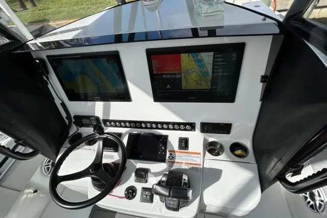 Slide: The Image of 2023 Contender 32 ST boat dashboard with dual navigation screens and steering wheel. - 17