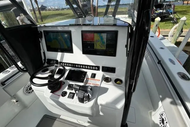 Slide: The Image of 2023 Contender 32 ST boat cockpit with dual navigation screens and control panel. - 18