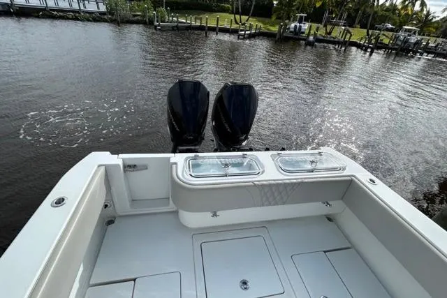 Slide: The Image of 2023 Contender 32 ST boat with dual outboard motors on a calm river. - 20