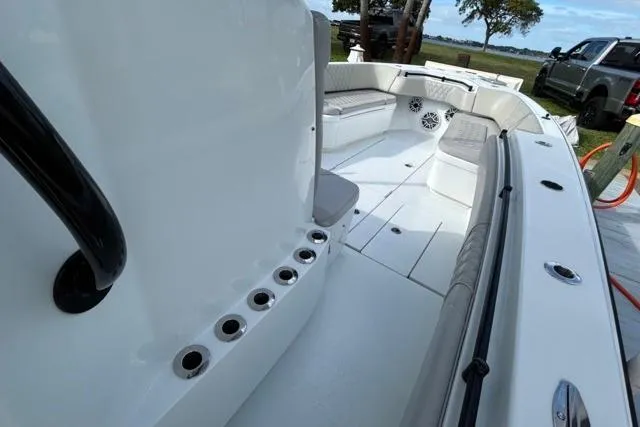 Slide: The Image of 2023 Contender 32 ST boat interior with seating and rod holders, docked outdoors. - 21
